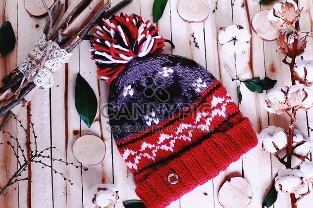 Wool hat and branches of cotton on wooden background - бесплатный image #136265
