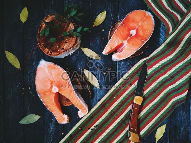 Salmon, bay leaves and knife on wooden background - Free image #136475