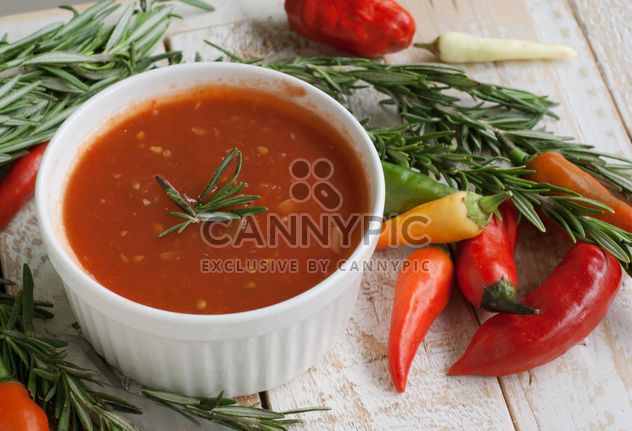 tomato sauce with rosemary and chili peppers on a wooden table - Free image #183365