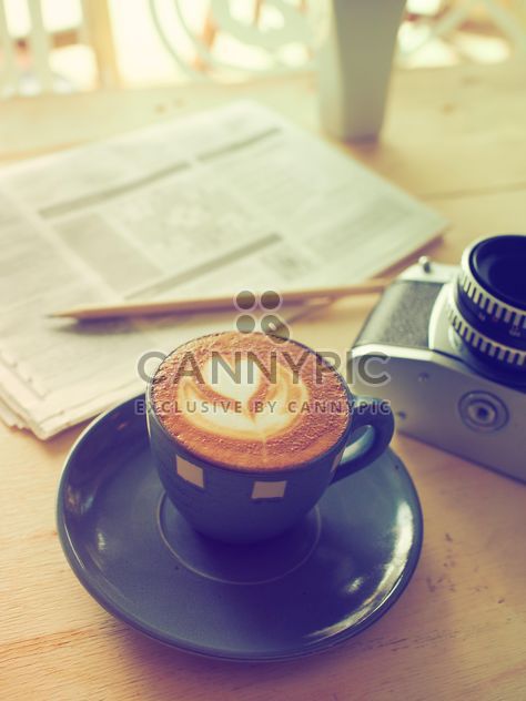 Latte, old camera and newspaper on the table - image gratuit #186945 