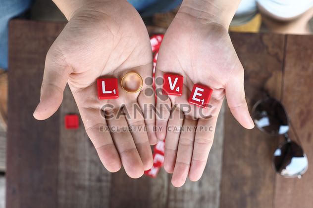 Word love of red cubes and wedding ring in hands - image gratuit #187155 