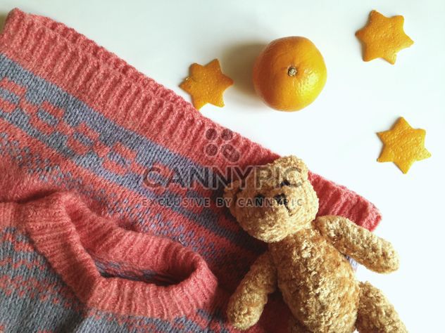 Children's sweater and a toy bear, tangerines on a white background - бесплатный image #198785