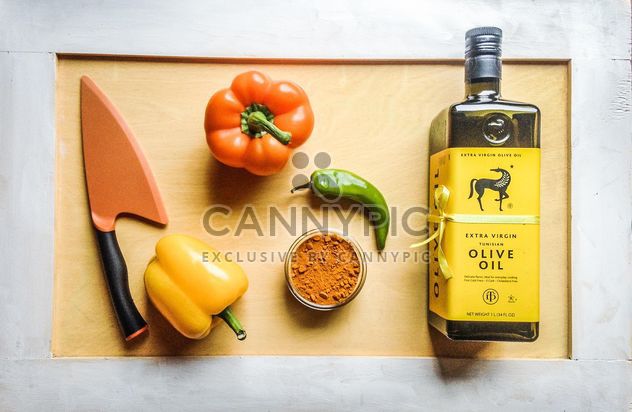 Olive oil, peppers and knife on wooden background - Free image #198935