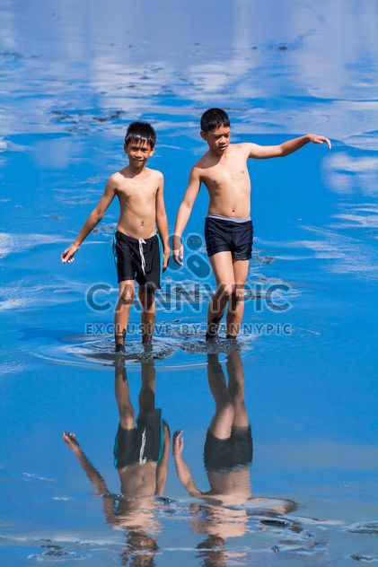 Two boys walking in water - Free image #273945