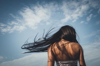 Rear view of girl with flying hair - image #301565 gratis