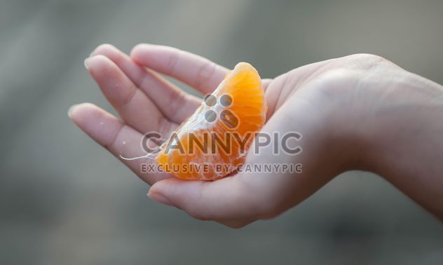 peeled tangerine in hand - бесплатный image #301975