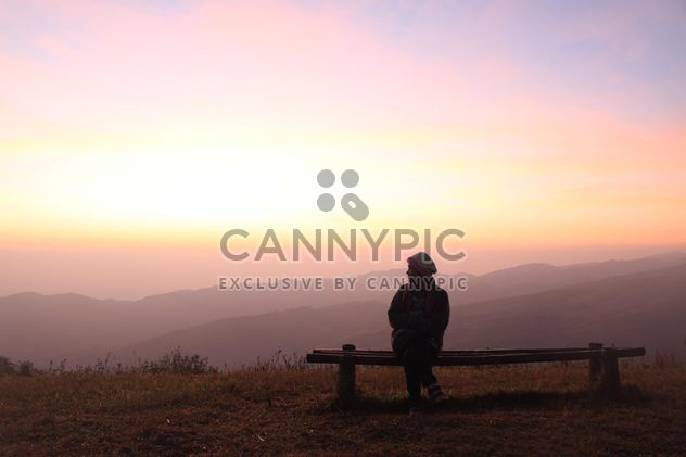 Woman sitting on bench at sunset - Free image #338505