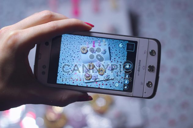 Smartphone decorated with tinsel in woman hands - Free image #342185