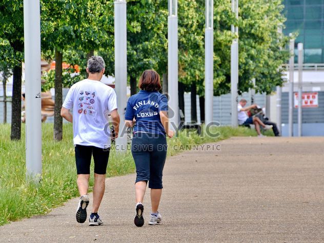 Rear view of senior couple jogging in park - image #344565 gratis