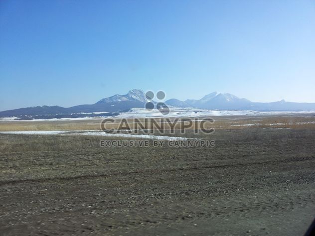 Mountains with snow in winter against the blue sky near the frozen lake - бесплатный image #350205
