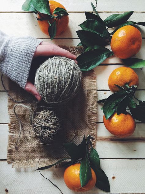Skeins of wool and tangerines on white wooden background - бесплатный image #136255