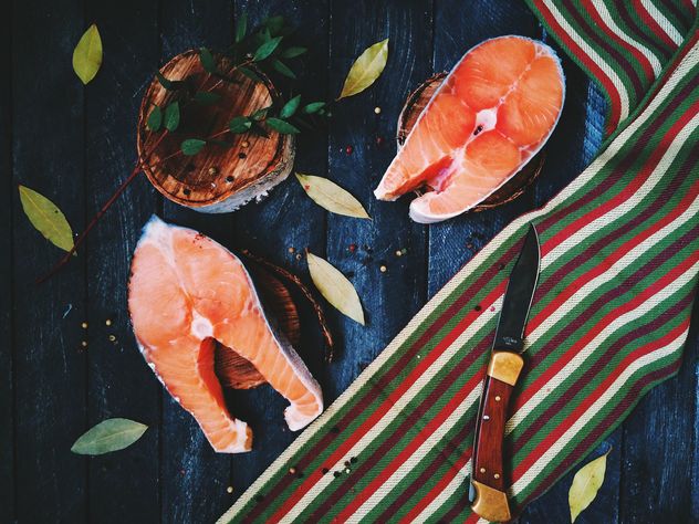 Salmon, bay leaves and knife on wooden background - бесплатный image #136475