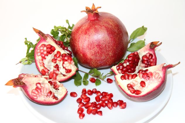 Ripe red pomegranate on white plate - Free image #187825