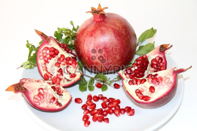 Ripe red pomegranate on white plate - image #187825 gratis