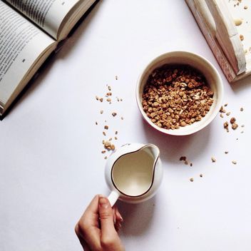 Oatmeal in a bowl, milk and book on white background - бесплатный image #198375