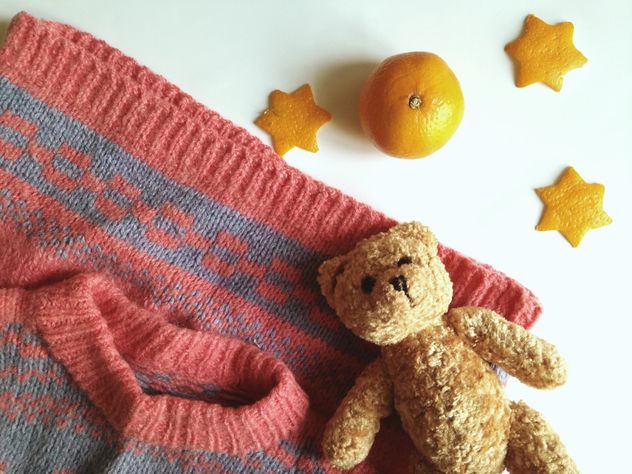 Children's sweater and a toy bear, tangerines on a white background - Free image #198785