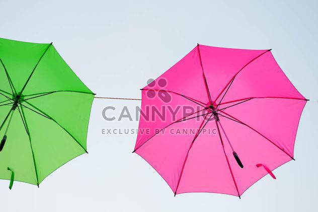Green and pink umbrellas hanging - image #273065 gratis