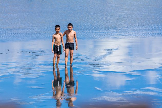 Two boys walking in water - Free image #273605