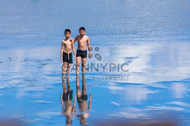 Two boys walking in water - бесплатный image #273605
