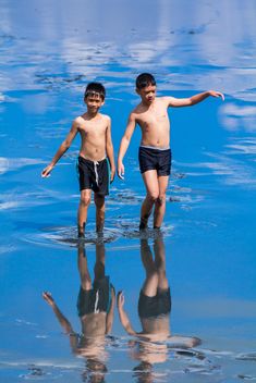 Two boys walking in water - бесплатный image #273945