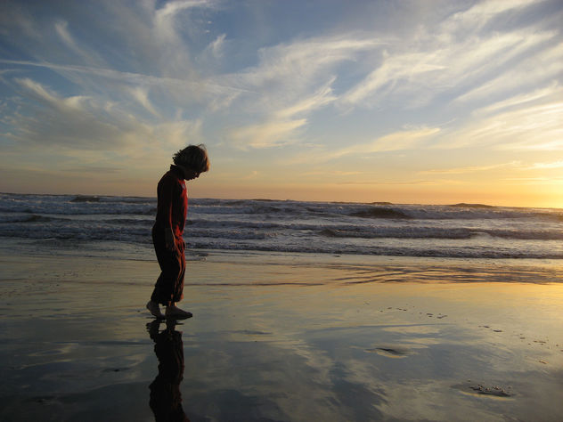 Kid on Beach Looking at the Sky in the Sand - image #278335 gratis