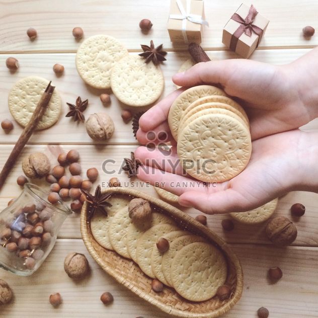 cookies in hands, nuts and anise on wooden background - Kostenloses image #329135
