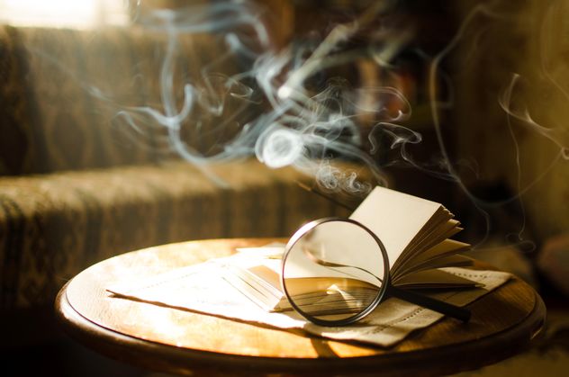 Burning incense sticks and open book through a magnifying glass - бесплатный image #330405