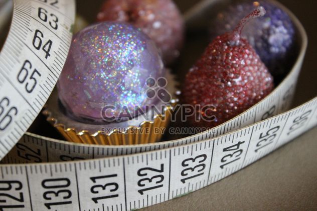 Still life of white measure tape with pink glitter toys - Free image #341455