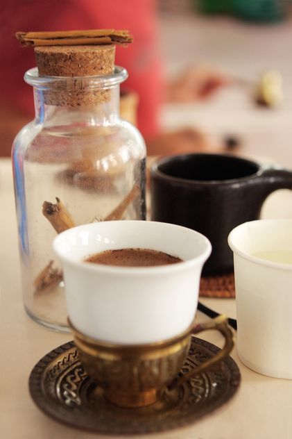 Cup of coffee and cinnamon in jar - бесплатный image #359175