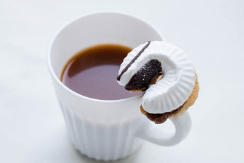 A cup of coffee and a cookie with a cream - image #449145 gratis