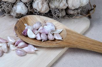 Garlic in a wooden spoon on the table. - Free image #452385