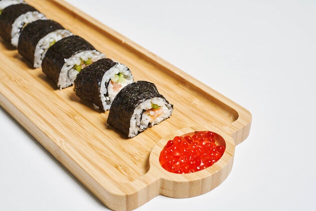 Sushi rolls served on a wooden plate in a restaurant - бесплатный image #481295